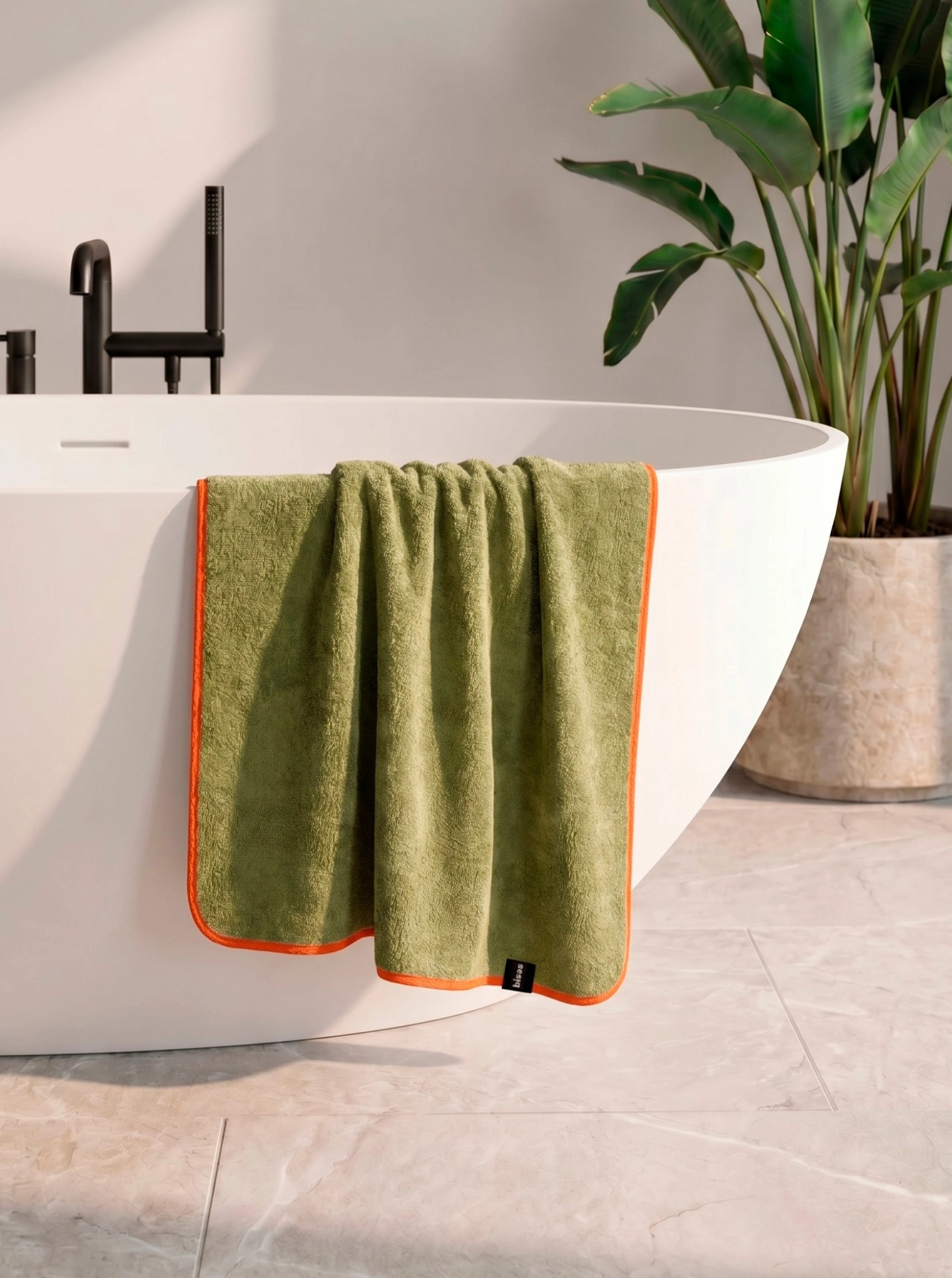 Рушник Bises Nature Bath у відтінку Pistachio Green з контрастною помаранчевою окантовкою на ванні